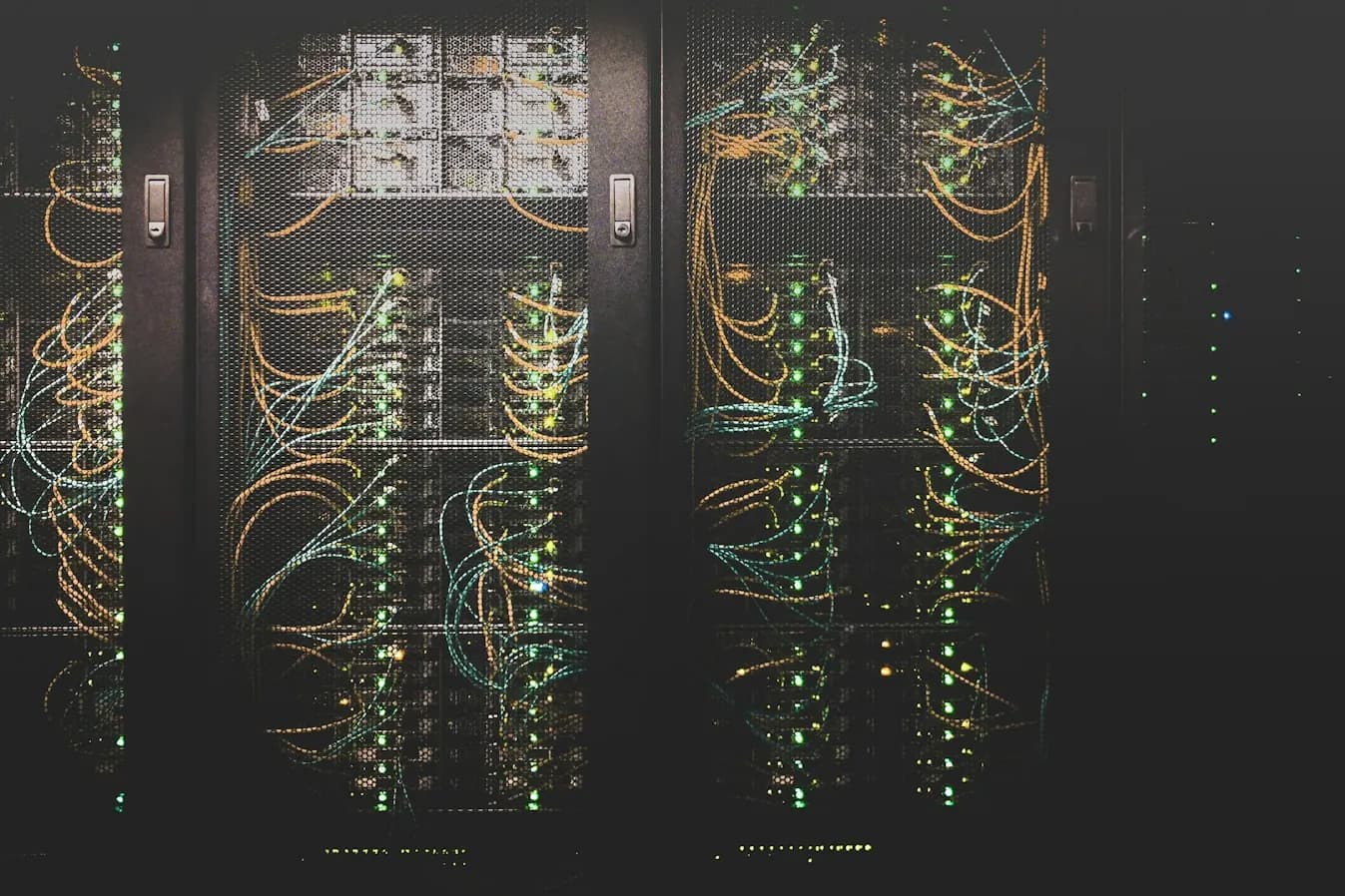 Serverschränke in einem abgedunkelten Rechenzentrum mit leuchtenden Netzwerkkabeln